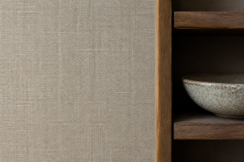 Close view of a textured wall surface beside a timber shelf for material and lighting comparison